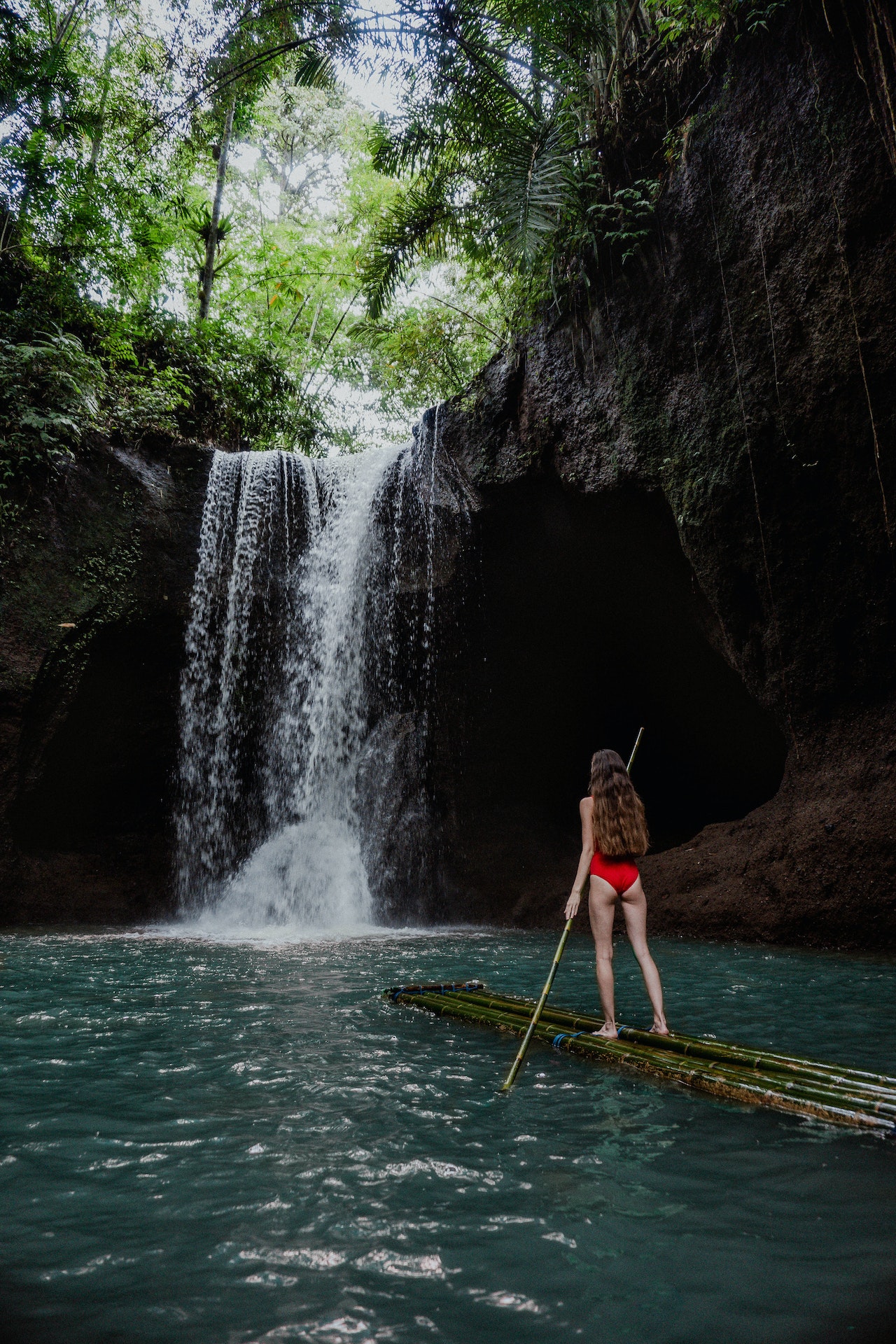 Woman on a raft in front of a stunning waterfall